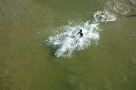 Kushtia District Khulna Division Bangladesh 10 March 2020 View of a man splashing in the river water creating ripples and spray on a sunny day. Kushtia District Khulna Division Bangladesh 10 March 2020 View of a man splashing in the river water creating ripples and spray on a sunny day.