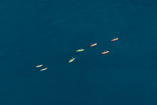 Aerial view of colorful kayaks paddling in the deep blue sea near Le Trayas in Saint Raphael Provence Alpes Cote d Azur France. Aerial view of colorful kayaks paddling in the deep blue sea near Le Trayas in Saint Raphael Provence Alpes Cote d Azur France.