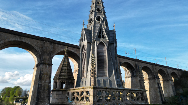 Aerial view of the gothic spire of Eglise Saint Melaine de Morlaix and the historic stone viaduct under a blue sky in Morlaix Bretagne France. Aerial view of the gothic spire of Eglise Saint Melaine de Morlaix and the historic stone viaduct under a blue sky in Morlaix Bretagne France.