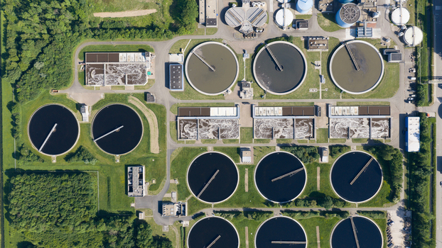 Aerial view of Rwzi Weurt wastewater treatment plant with circular clarifier tanks and rectangular aeration basins surrounded by greenery in Weurt Gelderland Netherlands. Aerial view of Rwzi Weurt wastewater treatment plant with circular clarifier tanks and rectangular aeration basins surrounded by greenery in Weurt Gelderland Netherlands.
