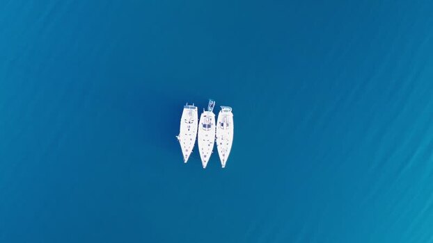 Aerial view of three sailboats in the deep blue water Norway.
