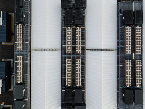 Aerial view of a data center facility featuring rows of cooling units and industrial equipment on a large white roof in Keflavik Reykjanesbaer Iceland. Aerial view of a data center facility featuring rows of cooling units and industrial equipment on a large white roof in Keflavik Reykjanesbaer Iceland.
