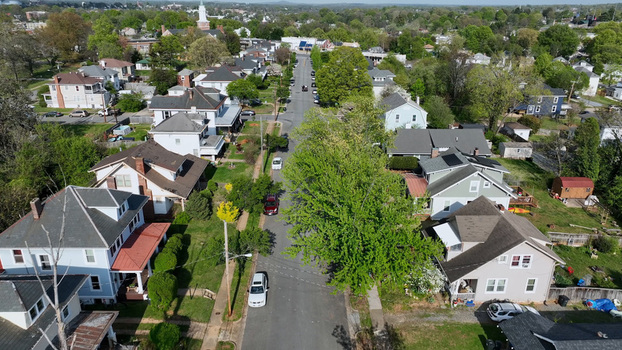 Aerial view of a quiet residential street lined with historic houses lush green trees and parked cars in Lynchburg Virginia United States.