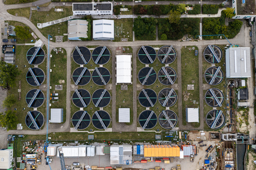 Aerial view of Klarwerk Ruhleben sewage treatment plant featuring circular sedimentation tanks and industrial infrastructure surrounded by green spaces Berlin Berlin Germany.
