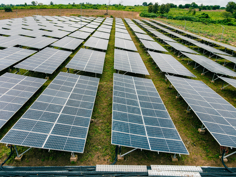 Aerial view of a large solar farm with rows of photovoltaic panels installed on green grassy fields in Ogun State Nigeria.