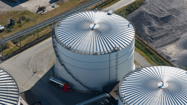 Aerial view of the Cosun Beet Company industrial facility featuring large white storage tanks and a red tanker truck parked on the asphalt in Groningen Groningen Netherlands. Aerial view of the Cosun Beet Company industrial facility featuring large white storage tanks and a red tanker truck parked on the asphalt in Groningen Groningen Netherlands.