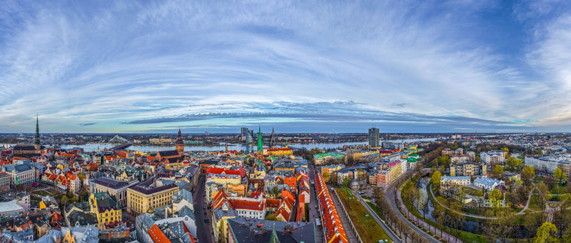 Aerial view of the historic city center of Riga featuring colorful rooftops church spires and the Daugava River under a vast blue sky Riga Latvia. Aerial view of the historic city center of Riga featuring colorful rooftops church spires and the Daugava River under a vast blue sky Riga Latvia.
