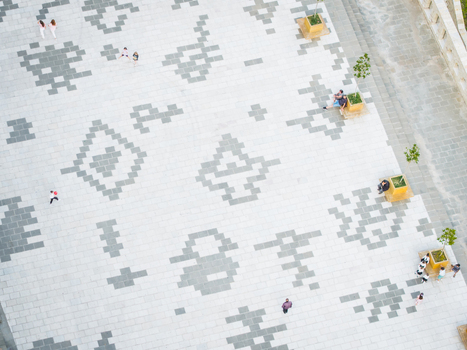 Aerial view of the geometric mosaic tiles of Cerciz Topulli Square with people walking and sitting by small trees in Gjirokaster Gjirokaster County Albania. Aerial view of the geometric mosaic tiles of Cerciz Topulli Square with people walking and sitting by small trees in Gjirokaster Gjirokaster County Albania.