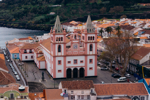 Aerial view of the Se Catedral de Angra do Heroismo with its pink facade and twin towers surrounded by traditional orange roofed houses in Angra do Heroismo Azores Portugal.