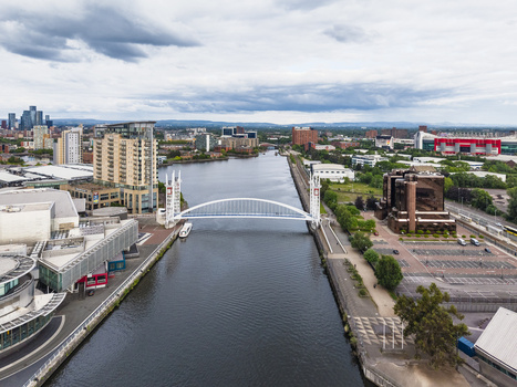 Aerial view of the Millennium Bridge spanning the Manchester Ship Canal surrounded by modern architecture and urban development in Stretford England United Kingdom.