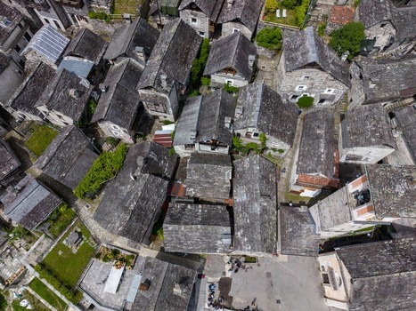 Aerial view of the traditional stone houses and grey slate roofs of Corippo Albergo Diffuso in the historic village of Corippo Ticino Switzerland. Aerial view of the traditional stone houses and grey slate roofs of Corippo Albergo Diffuso in the historic village of Corippo Ticino Switzerland.