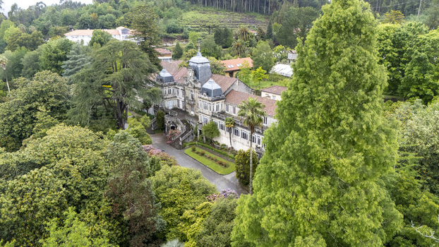 Agrovello Spain 03 May 2026 Aerial view of Pazo de Lourizan surrounded by lush botanical gardens historic stone architecture and dense green forest.