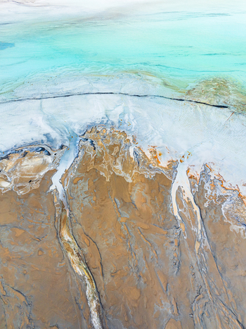 Aerial view of the intricate patterns of mineral rich salt flats with turquoise water and brown sediment in Andalusia Spain. Aerial view of the intricate patterns of mineral rich salt flats with turquoise water and brown sediment in Andalusia Spain.
