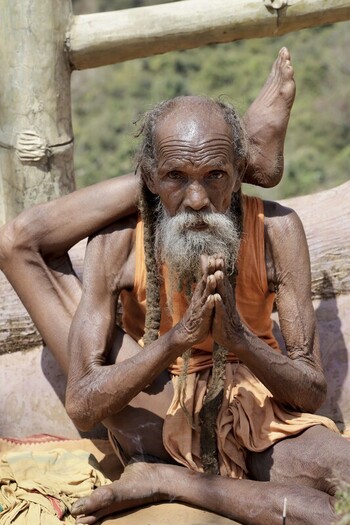Odisha India 26 March 2026 View of an old ascetic with weathered skin twisted limbs and a long beard sitting with hands clasped embodying resilience. Odisha India 26 March 2026 View of an old ascetic with weathered skin twisted limbs and a long beard sitting with hands clasped embodying resilience.