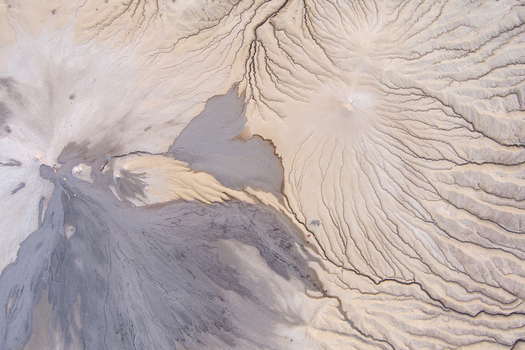 Aerial view of the mud volcanoes at Vulcanii Noroiosi Paclele Mari showing intricate grey mud flows and textured erosion patterns in the arid landscape of Paclele Buzau County Romania.