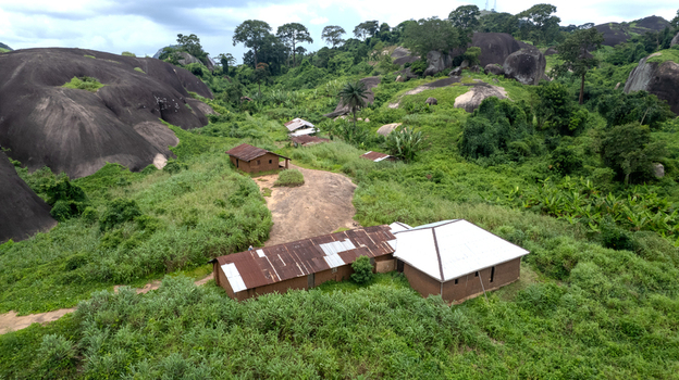 Aerial view of Idanre Hill featuring traditional buildings nestled among lush green vegetation and large granite rock formations in Idanre Ondo State Nigeria. Aerial view of Idanre Hill featuring traditional buildings nestled among lush green vegetation and large granite rock formations in Idanre Ondo State Nigeria.