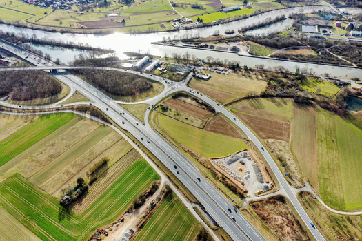 Aerial view of a highway interchange crossing through green agricultural fields near a river canal in Forchheim Bavaria Germany. Aerial view of a highway interchange crossing through green agricultural fields near a river canal in Forchheim Bavaria Germany.