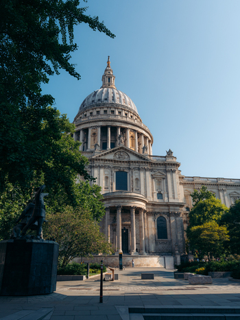 London United Kingdom 19 June 2025 View of St. Paul s Cathedral its pale stone facade contrasting with the deep greens of surrounding trees under a clear sky. London United Kingdom 19 June 2025 View of St. Paul s Cathedral its pale stone facade contrasting with the deep greens of surrounding trees under a clear sky.