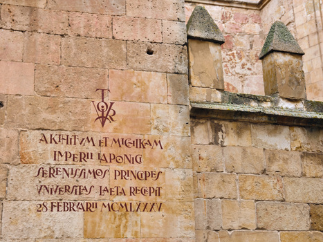 Salamanca Spain 29 November 2025 View of the historic stone wall of the University of Salamanca featuring a traditional Victor symbol and Latin inscriptions on weathered sandstone.