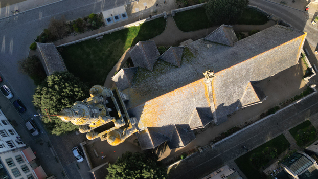 Aerial view of a stone church with a complex roof structure casting long shadows on the surrounding streets Roscoff Bretagne France. Aerial view of a stone church with a complex roof structure casting long shadows on the surrounding streets Roscoff Bretagne France.