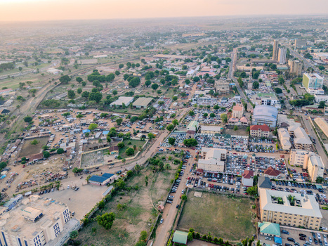 Aerial view of Ahmadu Bello Way with numerous cars in parking lots urban buildings and green trees under a hazy sky Kaduna Kaduna Nigeria. Aerial view of Ahmadu Bello Way with numerous cars in parking lots urban buildings and green trees under a hazy sky Kaduna Kaduna Nigeria.