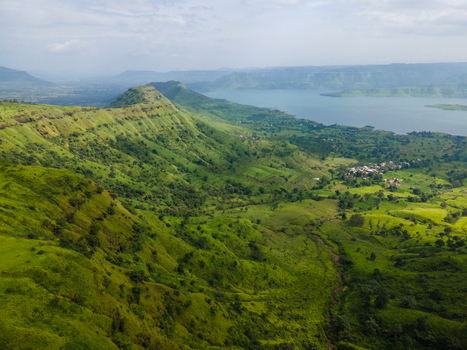 Aerial view of Kaas plateau with lush green hills and a lake in the background in Satara Maharashtra India.