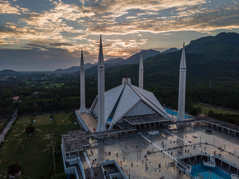 Aerial view of Faisal Masjid with its iconic minarets and tent shaped roof against the Margalla Hills at sunset in Islamabad Islamabad Capital Territory Pakistan. Aerial view of Faisal Masjid with its iconic minarets and tent shaped roof against the Margalla Hills at sunset in Islamabad Islamabad Capital Territory Pakistan.