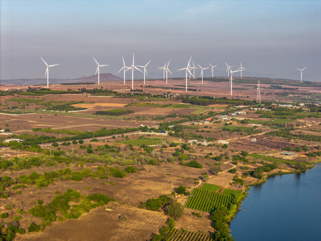 Aerial view of Phuoc Dinh Wind Farm with numerous wind turbines set against a landscape of dry fields agricultural plots and a reservoir in Phuoc Dinh Ninh Thuan Vietnam. Aerial view of Phuoc Dinh Wind Farm with numerous wind turbines set against a landscape of dry fields agricultural plots and a reservoir in Phuoc Dinh Ninh Thuan Vietnam.