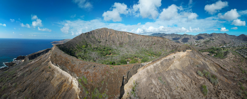Aerial view of the stark arid landscape of Koko Head volcano crater meets the deep blue ocean under a bright sky Honolulu Hawaii United States. Aerial view of the stark arid landscape of Koko Head volcano crater meets the deep blue ocean under a bright sky Honolulu Hawaii United States.