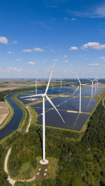 Aerial view of Zonnepark Eekerpolder featuring rows of solar panels and wind turbines set in a rural landscape with a canal and lush greenery in Scheemda Groningen Netherlands. Aerial view of Zonnepark Eekerpolder featuring rows of solar panels and wind turbines set in a rural landscape with a canal and lush greenery in Scheemda Groningen Netherlands.