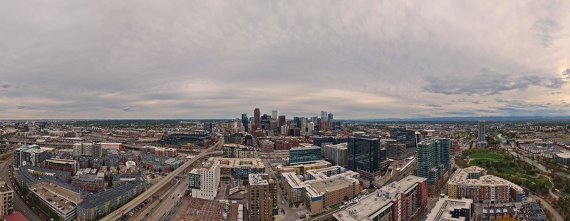 Aerial view of the Denver skyline featuring modern skyscrapers urban infrastructure and surrounding residential buildings under a cloudy sky in Denver Colorado United States. Aerial view of the Denver skyline featuring modern skyscrapers urban infrastructure and surrounding residential buildings under a cloudy sky in Denver Colorado United States.