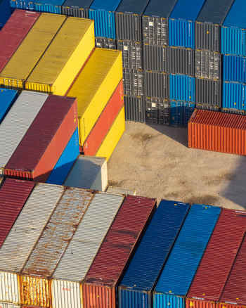Aerial view of cargo containers stacked in a shipping yard with vibrant colors and geometric patterns in Warsaw Masovian Voivodeship Poland.