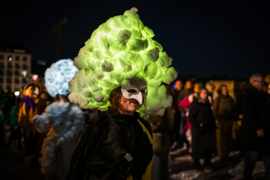 Basel Switzerland 10 March 2025 View of a luminous otherworldly figure in a feathered mask amidst the dark bustling energy of Fasnacht. Basel Switzerland 10 March 2025 View of a luminous otherworldly figure in a feathered mask amidst the dark bustling energy of Fasnacht.