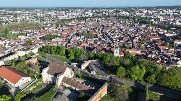 Aerial view of Besancon Citadel overlooking the historic city center with its red tiled rooftops and lush green trees under a clear blue sky in Besancon Bourgogne Franche Comte France. Aerial view of Besancon Citadel overlooking the historic city center with its red tiled rooftops and lush green trees under a clear blue sky in Besancon Bourgogne Franche Comte France.