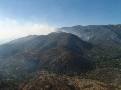 Aerial view of the Sierra de San Miguelito Norte mountains with smoke rising from a wildfire over the rugged landscape in San Luis Potosi San Luis Potosi Mexico.