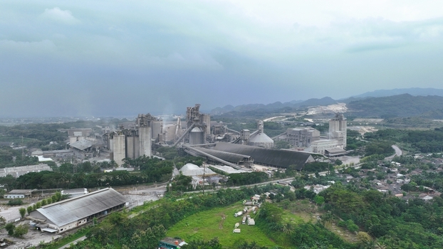 Aerial view of the Nambo cement factory with industrial silos and processing structures surrounded by lush greenery in Klapanunggal West Java Indonesia. Aerial view of the Nambo cement factory with industrial silos and processing structures surrounded by lush greenery in Klapanunggal West Java Indonesia.