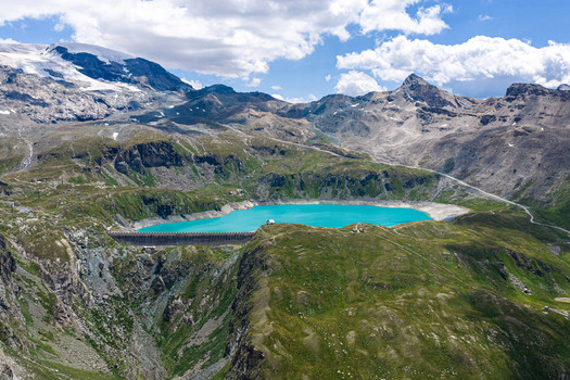 Aerial view of the Goillet Dam and its turquoise reservoir surrounded by the rugged peaks and green slopes of the Aosta Valley in Breuil Cervinia Aosta Valley Italy. Aerial view of the Goillet Dam and its turquoise reservoir surrounded by the rugged peaks and green slopes of the Aosta Valley in Breuil Cervinia Aosta Valley Italy.