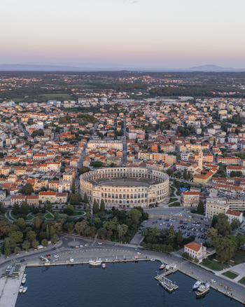 Aerial view of the historic Pula Arena amphitheater surrounded by the urban cityscape harbor and Adriatic Sea in Pula Istarska zupanija Croatia. Aerial view of the historic Pula Arena amphitheater surrounded by the urban cityscape harbor and Adriatic Sea in Pula Istarska zupanija Croatia.