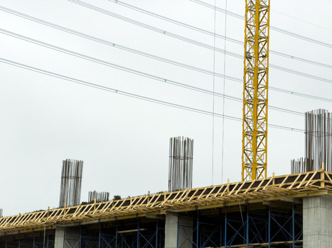 View of a construction site featuring a yellow tower crane concrete pillars with steel rebar and wooden formwork under an overcast sky in Beylikduzu Istanbul Turkiye. View of a construction site featuring a yellow tower crane concrete pillars with steel rebar and wooden formwork under an overcast sky in Beylikduzu Istanbul Turkiye.