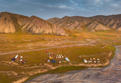 Aerial view of the yurt camp near the Kol Suu lake area with mountains in the background under golden hour light in At Bashi District Naryn Region Kyrgyzstan. Aerial view of the yurt camp near the Kol Suu lake area with mountains in the background under golden hour light in At Bashi District Naryn Region Kyrgyzstan.