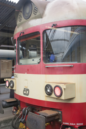View of the front of a red and cream colored train with circular headlights and the Czech Railways logo at a station platform in Berlin Berlin Germany.