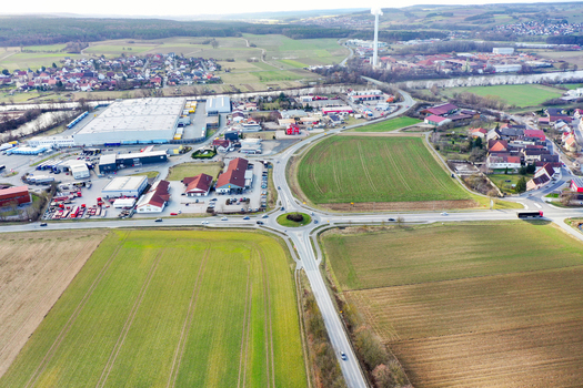 Aerial view of a traffic roundabout surrounded by industrial warehouses and vast agricultural fields Forchheim Bavaria Germany. Aerial view of a traffic roundabout surrounded by industrial warehouses and vast agricultural fields Forchheim Bavaria Germany.