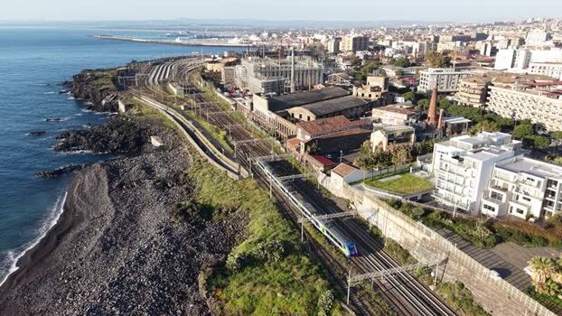 Aerial view of a train traveling along the coast in Catania Italy. Aerial view of a train traveling along the coast in Catania Italy.