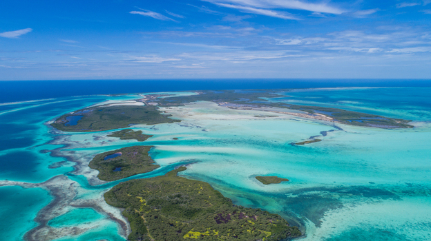 Aerial view of Los Roques archipelago with turquoise waters coral reefs and small islands under a clear blue sky in Los Roques Dependencias Federale Venezuela. Aerial view of Los Roques archipelago with turquoise waters coral reefs and small islands under a clear blue sky in Los Roques Dependencias Federale Venezuela.