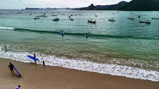 Aerial view of surfers on a beach in Bali Indonesia.
