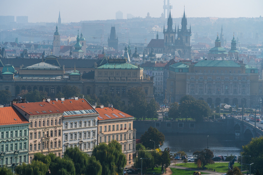 View of the historic city of Prague with the Vltava River the Church of Our Lady before Tyn and traditional architecture under a soft hazy sky in Prague Prague Czechia.