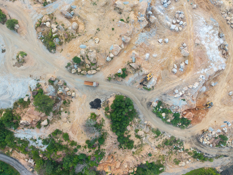 Aerial view of a mining site with heavy machinery dirt roads and rocky terrain in Bukit Tambun Penang Malaysia. Aerial view of a mining site with heavy machinery dirt roads and rocky terrain in Bukit Tambun Penang Malaysia.