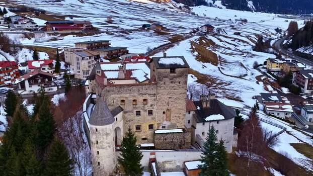 Aerial view of Schloss Naudersberg in the snowy mountains of Austria.