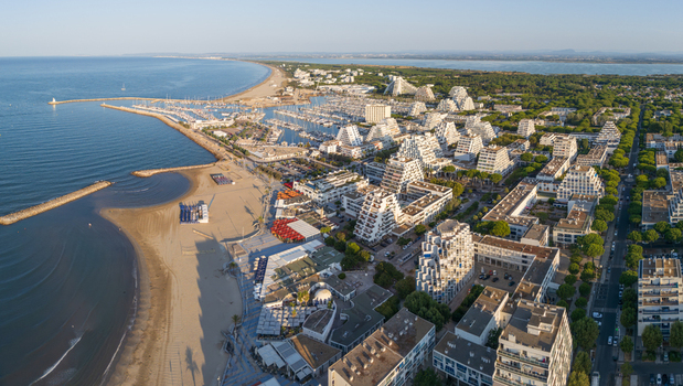 Aerial view of the distinctive pyramid shaped architecture marina and sandy beach of the coastal town in La Grande Motte Occitanie France.