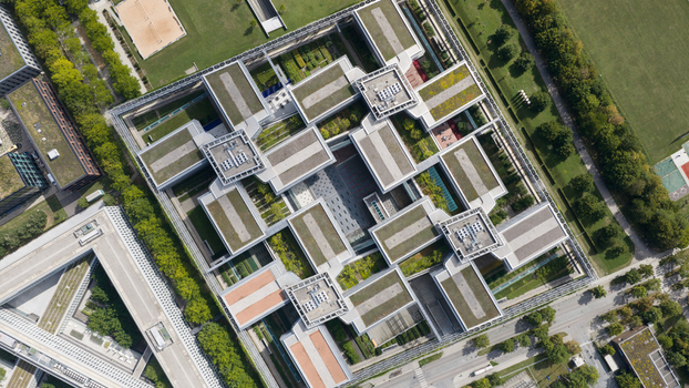 Unterfohring Germany 12 September 2026 Aerial view of Allianz Commercial headquarters featuring a modern complex with interconnected buildings green rooftop gardens and central courtyards.